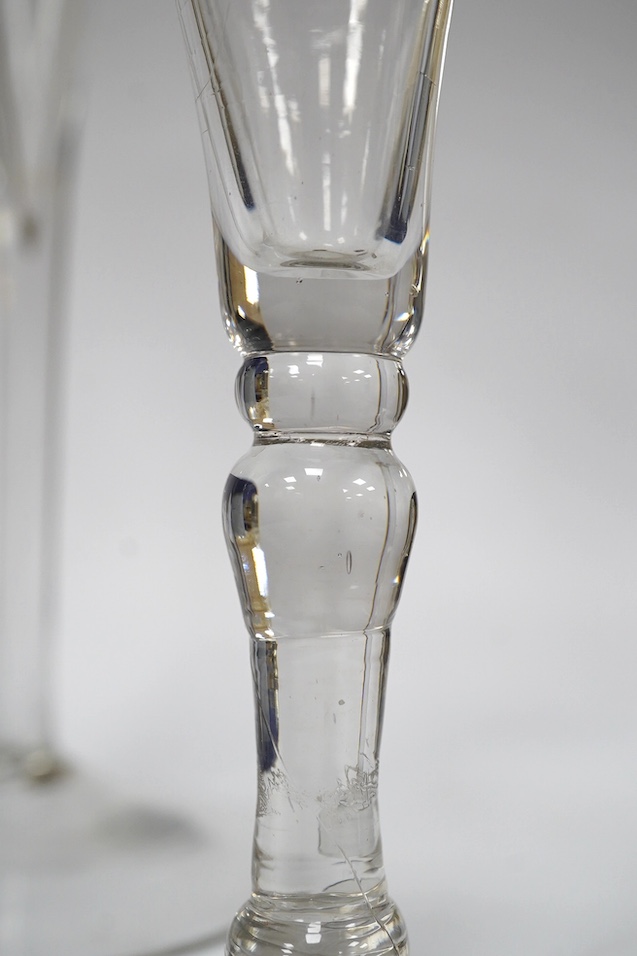 Two drawn trumpet wine glasses, late 18th century and a balustroid gin glass, c.1740, 12.4cm - 18.7cm high (3). Condition - the slender trumpet wine glass has some glue residue to the pontil mark but there is no evidence